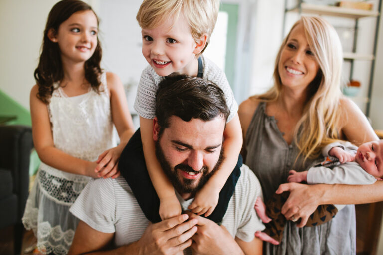 Junge fröhliche Familie mit Kindern und Baby in Wohnung